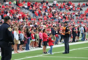 Security personnel overseeing a high school football game crowd