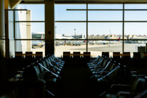 Empty airport gate seating with planes on the tarmac